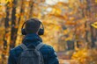 Man on walk in nature while listening to music on the radio or podcast with wireless headphones
