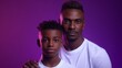African-american father and son portrait on gradient studio background in neon. Beautiful male models in casual style, white shirt. Concept of human emotions, facial expression.