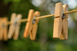 Wooden clothespins hang on a string outdoor