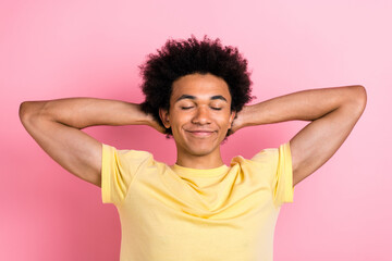 Poster - Photo of nice young man arms behind head closed eyes sleep wear yellow t-shirt isolated on pink color background