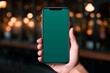 App mockup shoulder view of a girl holding an smartphone with a completely green screen