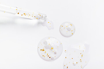 serum pipette serum gel essence texture with gold on white background