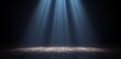Photo of an empty stage with spotlights shining down, creating dramatic lighting. 