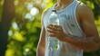 Man wearing white fitness sleeveless shirt holding plastic water bottle on blurred green AI generated