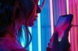 Ui mockup through a shoulder view of a woman holding an smartphone with a completely neon screen
