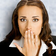 Square image - excited surprised, shocked, astonished young businesswoman. Business woman covering mouth by her hand, against white bricks loft wall background.