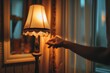 Close-up of a hand turning off a floor lamp in a bedroom
