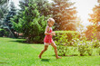 © Maryana - Having fun with Water Garden Sprinklers in Beautiful Garden with Flowers and Sunlight. Child Running Barefoot on Green Nature Background. Happy Children Summer Holidays.
