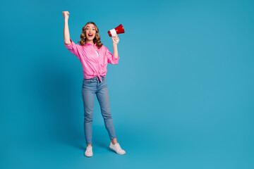 Poster - Full body photo of pretty young girl hold megaphone raise fist wear trendy pink outfit hairdo isolated on blue color background