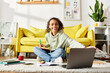 © LIGHTFIELD STUDIOS - A teenage girl sits on the floor, focused on her laptop screen, actively engaged in e-learning at home.