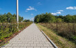 Chodnik wzdłuż drogi prowadzącej przez tereny leśne, przez miejskie obszary  (w Ostrowcu), we wrześniowy poranek.