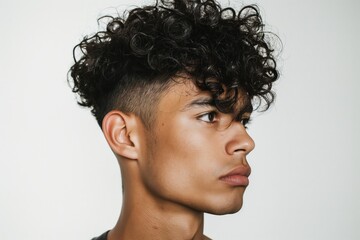 Wall Mural - Side profile of a trendy curly undercut hairstyle on a young adult male against a white background