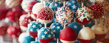 Patriotic Themed Cake Pops Decorated With Stars And Stripes In Red, White, And Blue.