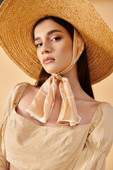 A young woman with long brunette hair strikes a pose in a studio, exuding a summer mood with a straw hat and scarf.