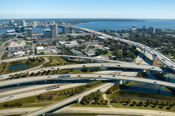 Wall Mural - Aerial view of Jacksonville city with high office buildings and american freeway intersection with fast moving cars and trucks. USA transportation infrastructure concept