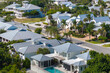 Expensive mansions between green palm trees in southwest Florida suburbs, USA. Aerial view of wealthy waterfront neighborhood