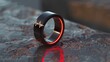 Black Ring With Heartbeat Engraving on Textured Surface at Dusk