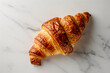 Golden Flaky Croissant on a Marble Surface Close-Up