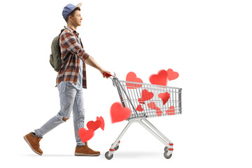 Wall Mural - Full length profile shot of a male student pushing a shopping cart with hearts