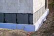waterproof thermal insulation coatings on the Foundation of the bottom wall in a new private house under construction.   Extruded Polystyrene foam, membrane and bitumen