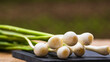Close up of details of fresh green onions (scallion) on a cutting board isolated.