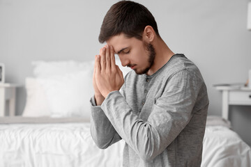Wall Mural - Young man praying in bedroom