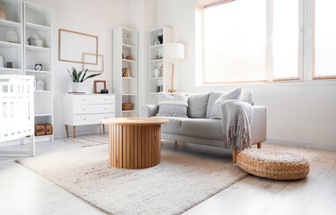 Poster - Interior of living room with sofa, table and baby crib