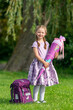 blondes glückliches stolzes sechsjähriges Mädchen mit Schultüte und Schulrucksack, erstklässlerin, sonniger tag, schulanfang