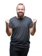 © Krakenimages.com - Young caucasian hipster man over isolated background celebrating surprised and amazed for success with arms raised and open eyes. Winner concept.