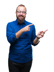 Wall Mural - Young caucasian hipster man wearing glasses over isolated background smiling and looking at the camera pointing with two hands and fingers to the side.