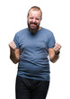 © Krakenimages.com - Young caucasian hipster man over isolated background very happy and excited doing winner gesture with arms raised, smiling and screaming for success. Celebration concept.