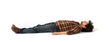 Fototapeta Most - Man Sleeping concept. Eyes closed. Plaid shirt and jean pants. Laying on the isolated white background. Can also represent Fainted, dead, relaxed, relaxation, drunk.