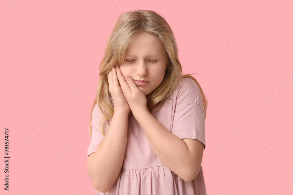 Young girl suffering from toothache on pink background