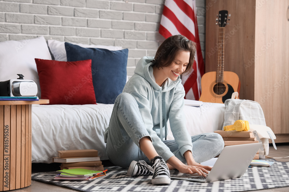 Female student studying with laptop in bedroom