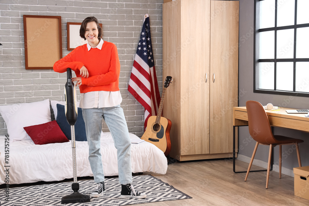 Female student with vacuum cleaner in bedroom