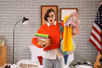 Canvas Print - Stressed female student with books and clothes in bedroom