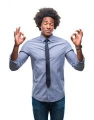 Canvas Print - Afro american business man over isolated background relax and smiling with eyes closed doing meditation gesture with fingers. Yoga concept.