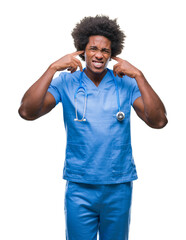 Wall Mural - Afro american surgeon doctor man over isolated background covering ears with fingers with annoyed expression for the noise of loud music. Deaf concept.