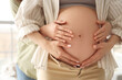© Pixel-Shot - Young pregnant woman with her wife touching belly at home, closeup