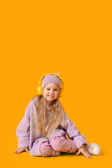 Sticker - Cute little girl in adult clothes with headphones on yellow background