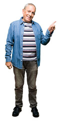 Sticker - Handsome senior man wearing denim jacket with a big smile on face, pointing with hand and finger to the side looking at the camera.