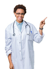 Wall Mural - Young african american doctor woman wearing medical coat over isolated background with a big smile on face, pointing with hand and finger to the side looking at the camera.