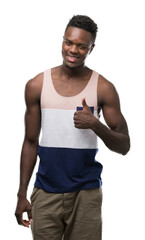 Sticker - Young african american man happy with big smile doing ok sign, thumb up with fingers, excellent sign