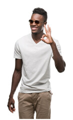 Sticker - Young african american man wearing sunglasses doing ok sign with fingers, excellent symbol