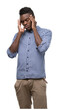 Young african american man wearing blue shirt with hand on head for pain in head because stress. Suffering migraine.