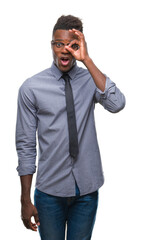 Sticker - Young african american business man over isolated background doing ok gesture shocked with surprised face, eye looking through fingers. Unbelieving expression.