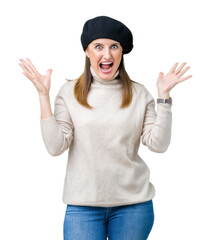 Sticker - Middle age mature woman wearing winter sweater and beret over isolated background celebrating crazy and amazed for success with arms raised and open eyes screaming excited. Winner concept