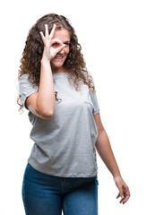 Sticker - Beautiful young brunette curly hair girl wearing casual look over isolated background doing ok gesture with hand smiling, eye looking through fingers with happy face.