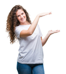 Sticker - Beautiful brunette curly hair young girl wearing casual t-shirt over isolated background gesturing with hands showing big and large size sign, measure symbol. Smiling looking at the camera.