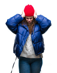 Wall Mural - Beautiful young brunette curly hair girl wearing winter coat, wool cap and sweater over isolated background suffering from headache desperate and stressed because pain and migraine. Hands on head.